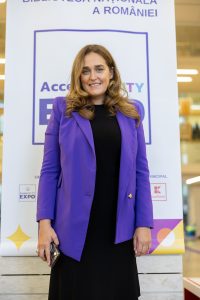 Estera Anghelescu standing in front of a banner saying AccessABILITY Expo - only just seen