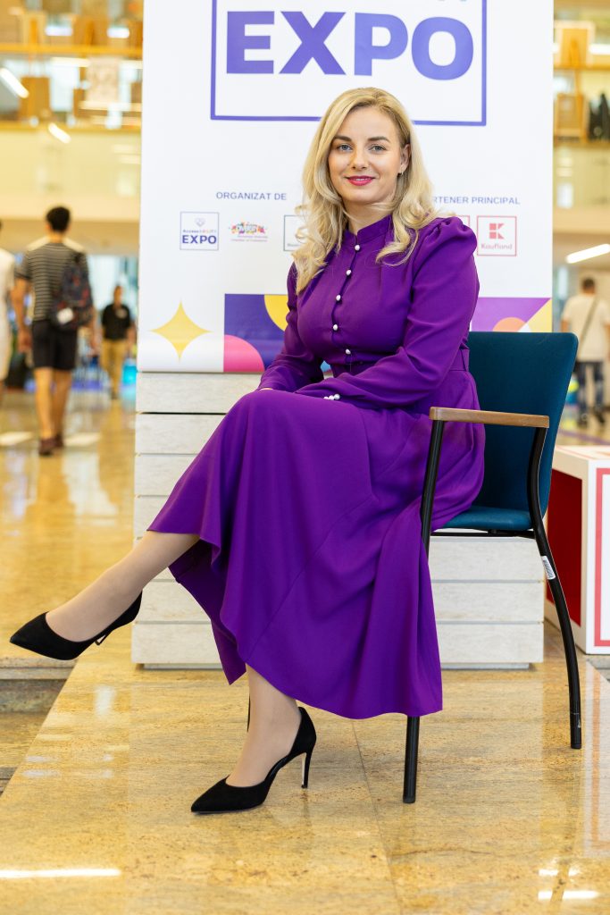Lorenne Stefan sitting on a chiar in front of a banner saying Expo